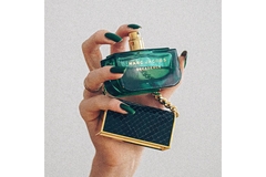 Image A hand holding a Marc Jacobs perfume.